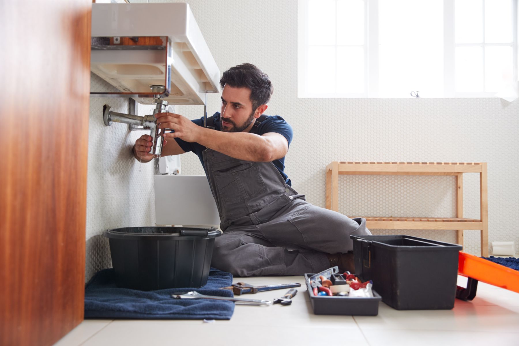male-plumber-working-to-fix-leaking-sink-in-home-.jpg